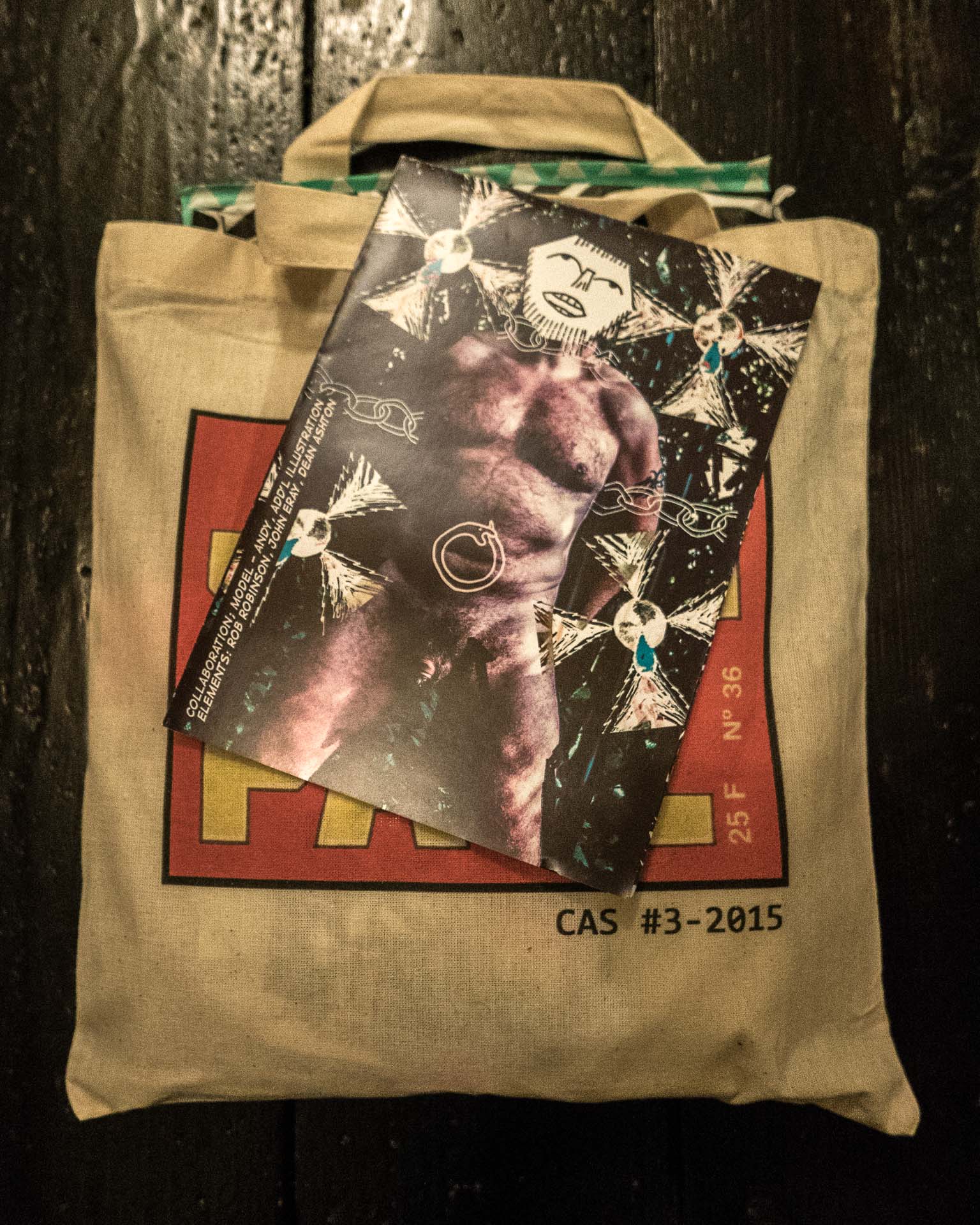 The San(t)s Sebastians zine atop the 'Cock au Soleil' Vol.3 Tote Bag.
